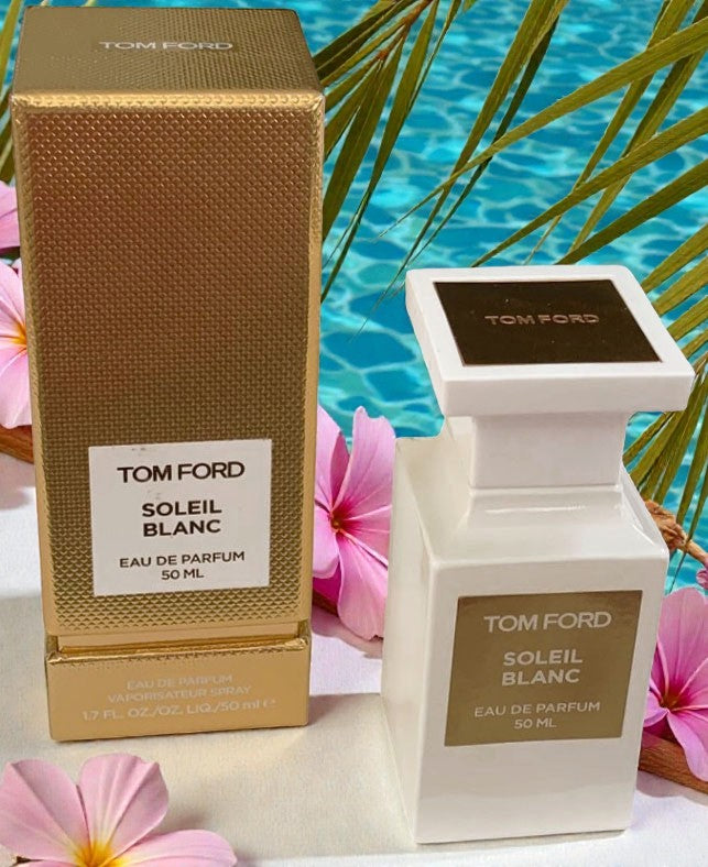 Tom Ford Soleil Blanc perfume bottle and packaging with a pool and flowers in the background