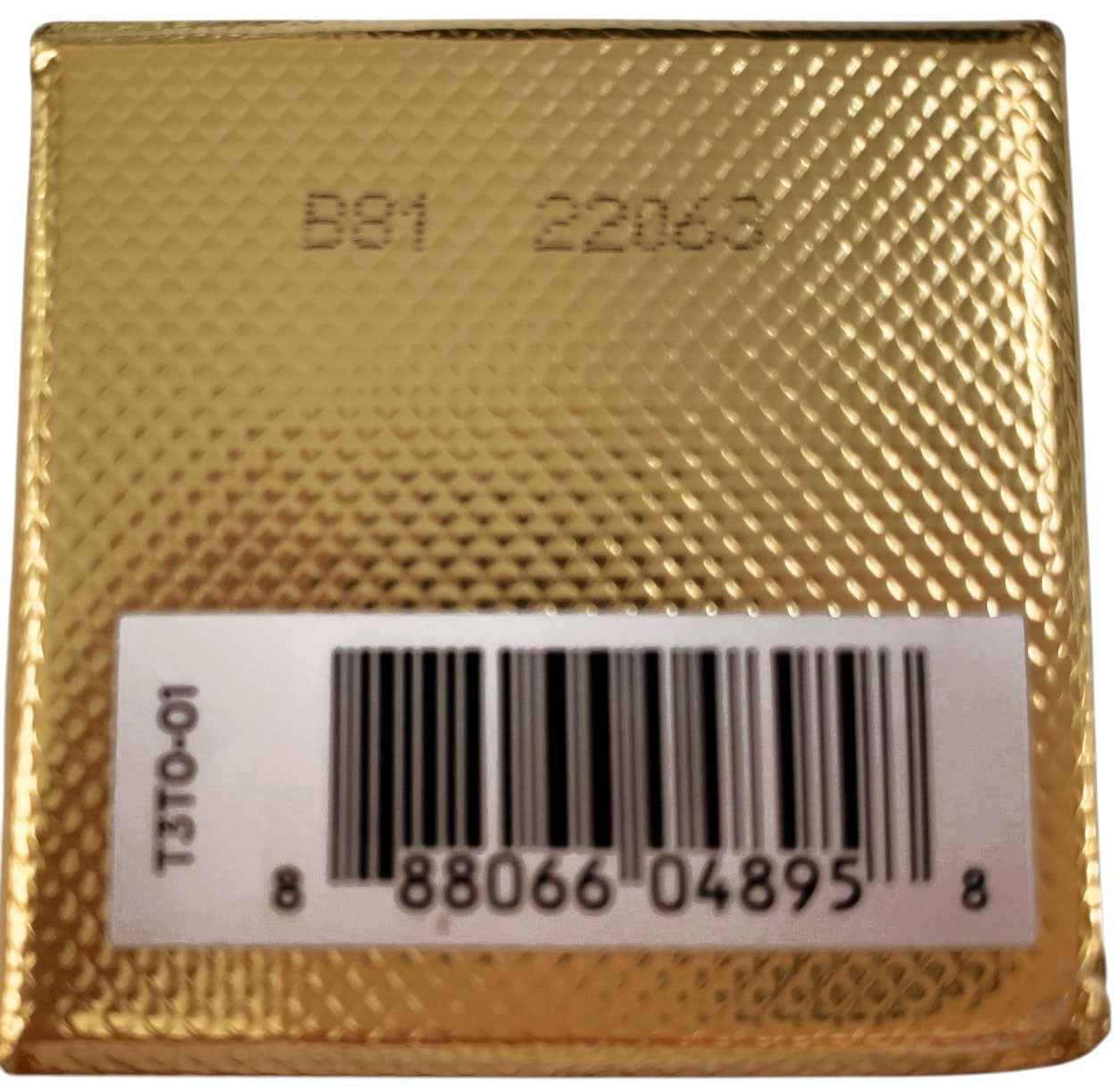 Gold foil label with a barcode and text on a white background