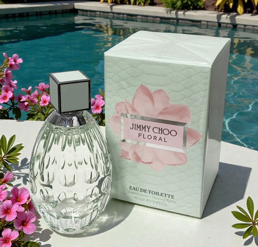 Jimmy Choo floral eau de toilette with packaging by a poolside