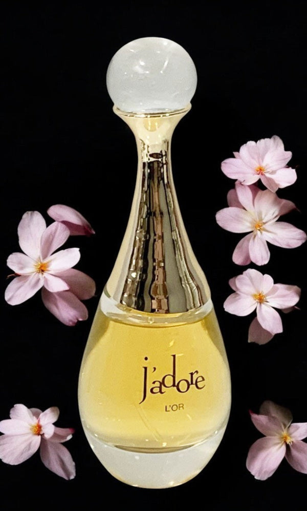 J'adore perfume bottle with pink flowers on a black background