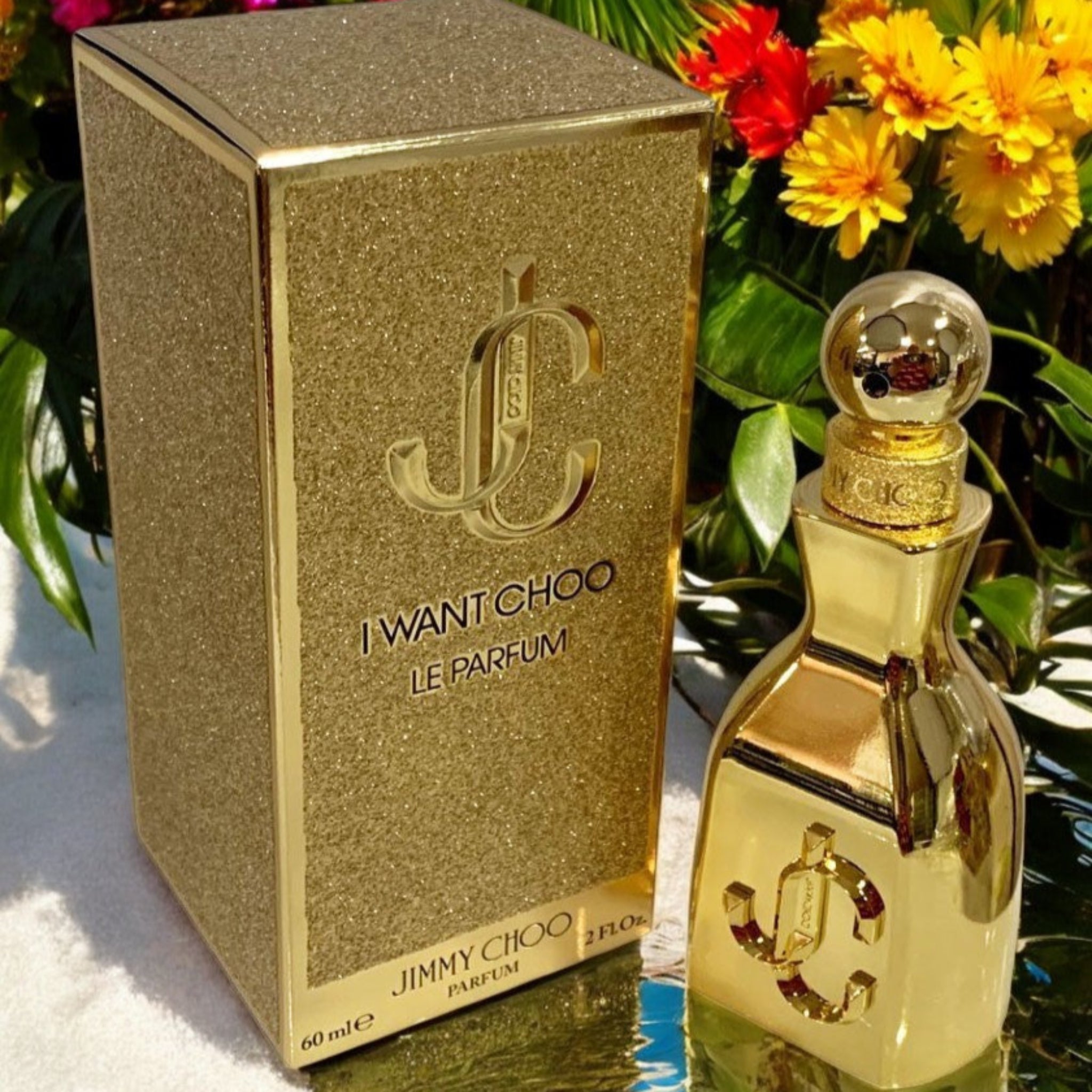 Gold Jimmy Choo perfume bottle and packaging with flowers in the background